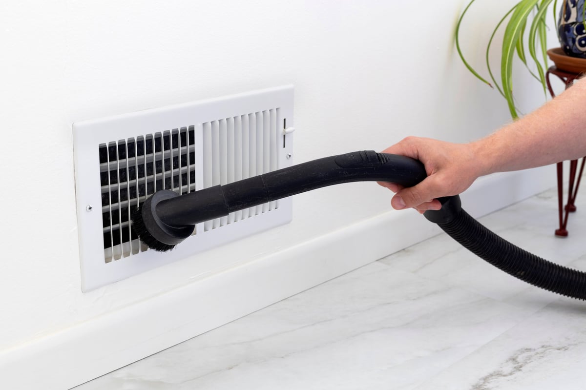 Cleaning a dryer vent air vent cover with a vacuum