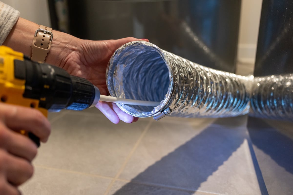 Technician cleaning a residential dryer vent