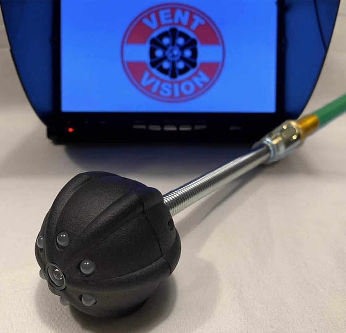 A spherical camera device with multiple lenses on a metal probe, displayed next to a monitor showing a Vent Vision logo